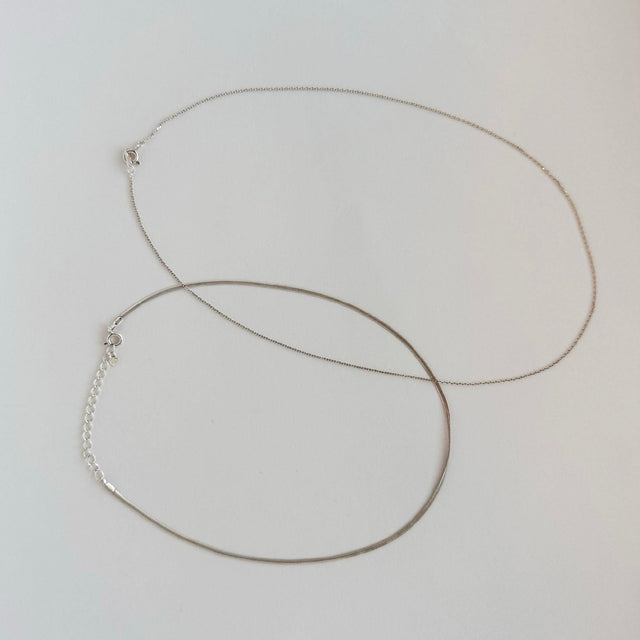 A versatile sterling silver necklace set with dual chain styles, offering the flexibility to wear each chain separately or together for a stylish layered look. This exquisite set embodies elegance and can be cherished individually or shared as a symbol of connection