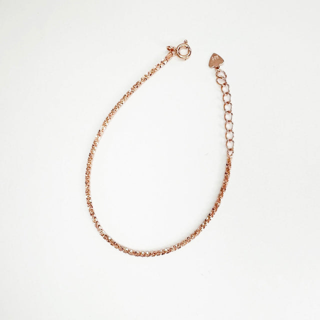 A dainty and sophisticated 14 rose gold-plated flower chain bracelet, showcasing a unique and captivating design. Its delicate floral motifs delicately intertwine, creating an enchanting and elegant accessory that effortlessly elevates your style.