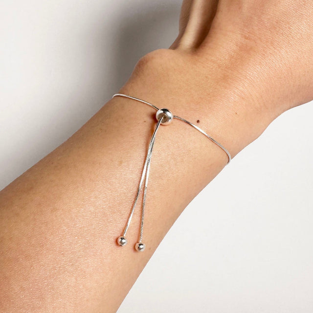 A dainty, sophisticated, and modern sterling silver adjustable bracelet, exuding simplicity and luxury. This elegant accessory effortlessly adorns your wrist with a touch of refined charm, making it a versatile and timeless addition to your jewelry collection.