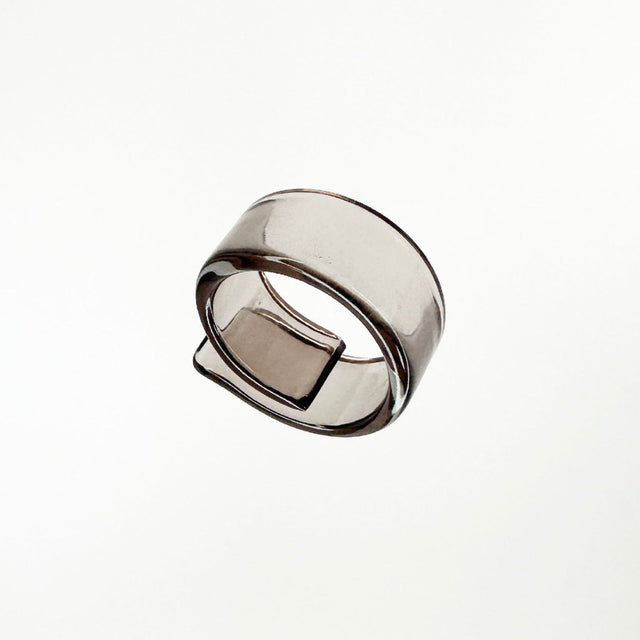 Striking clear black ring with an intriguing and distinctive shape, embodying a captivating blend of modernity and elegance. This unique piece of jewelry showcases a sleek design, making a bold statement while effortlessly complementing any style