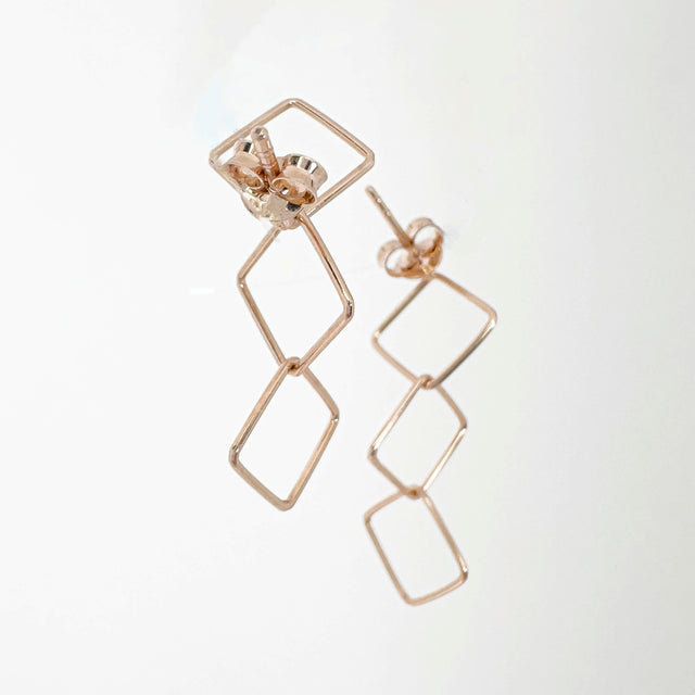 Gracefully mobile, these 14k rose gold-plated sterling silver earrings feature three interconnected squares, allowing them to sway and dance with your every move. With their captivating design and fluid motion, these earrings effortlessly enhance your style with a touch of elegance and playfulness.